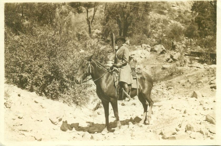 older lady in fancy riding outfit hat n high boots on horse in western 